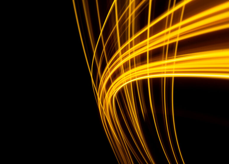 a long exposure photo of a yellow light trail on a black background. High quality